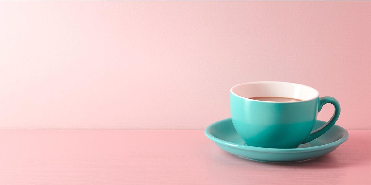 Green coffee cup with pink background