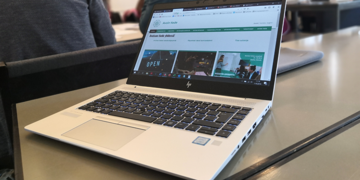 Laptop on a table with the open science website on.