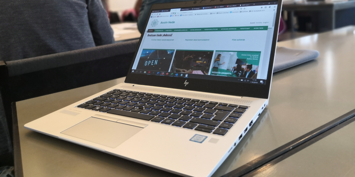 Laptop on a table with the open science website on. 