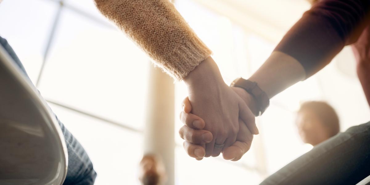 Kuvituskuva, jossa ihmiset pitävät toisiaan kädestä kiinni aurinkoisessa huoneessa.