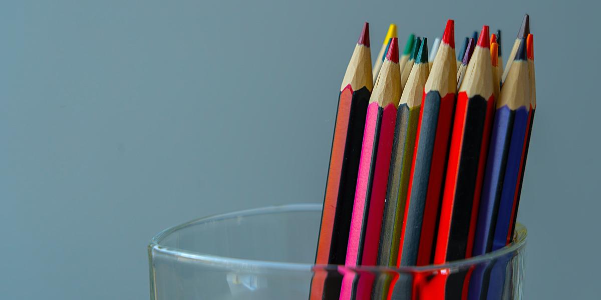 Illustration: Coloured pencils of different colours in a glass. 