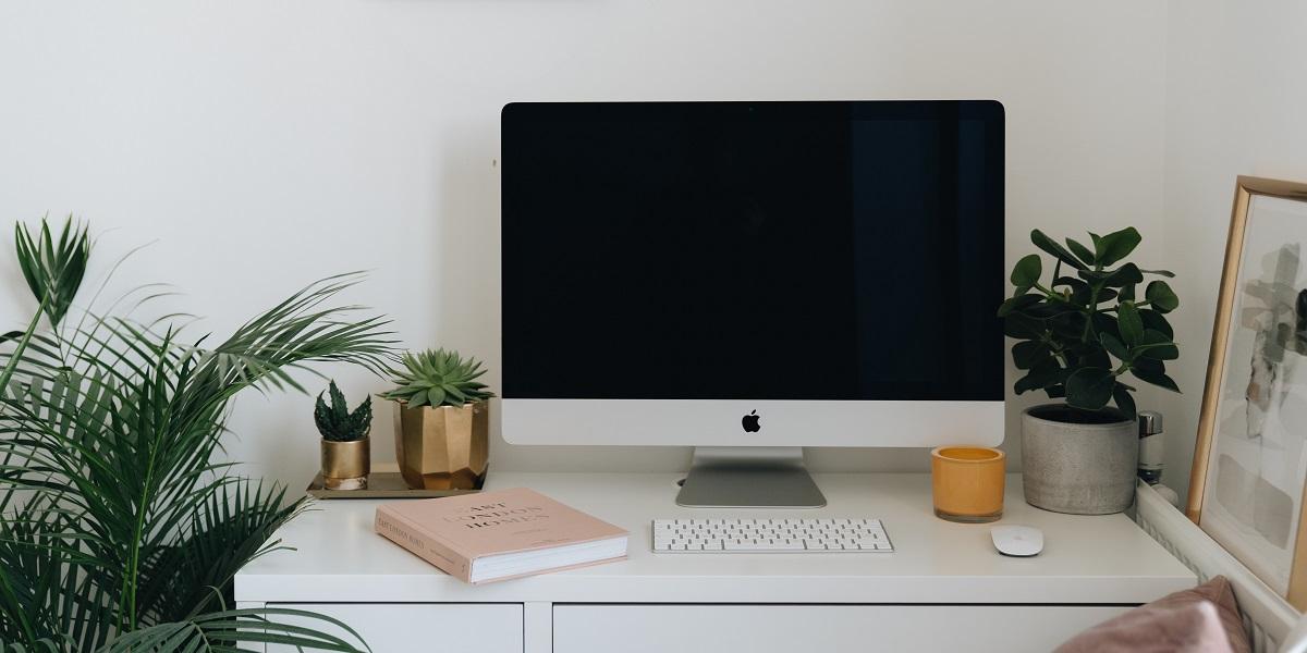 Image of an office desk with a screen and key on it 