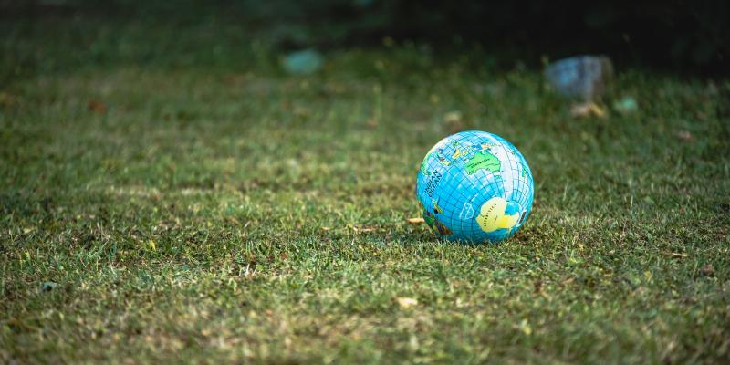 Maapallokuvioinen pallo nurmikolla.