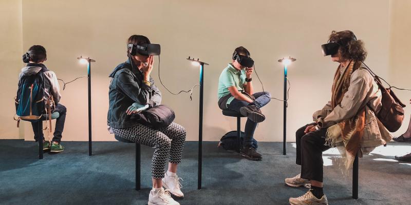 Ihmisiä istuu museossa VR-lasit päässään. 