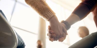 Kuvituskuva, jossa ihmiset pitävät toisiaan kädestä kiinni aurinkoisessa huoneessa.