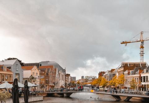 Stadsvy i Leiden, Nederländerna: flod, hus och en lyftkran