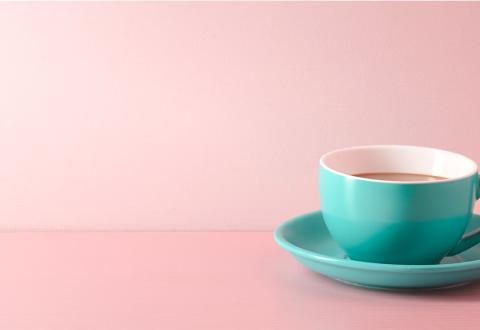 Green coffee cup with pink background