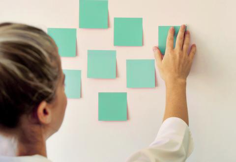 Kuvituskuva jossa vihreitä tyhjiä post-it lappuja seinällä