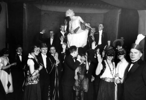 Svartvit bild på festfolk i maskeraddräkter, 1920-tal.